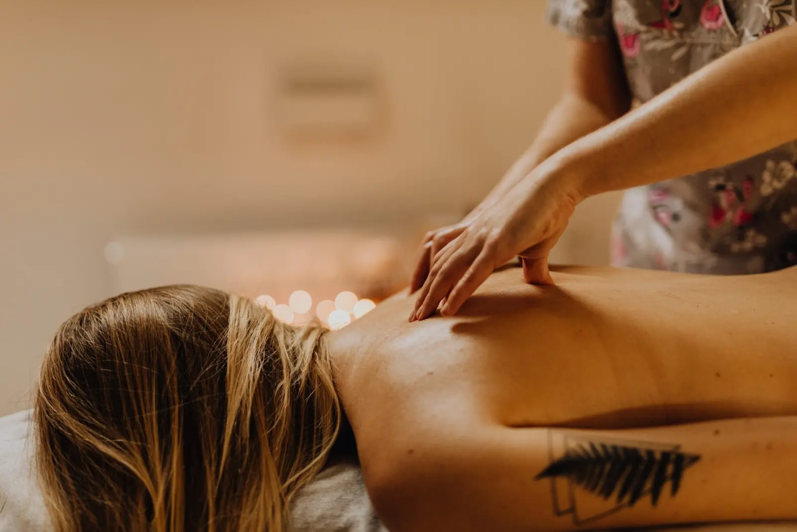 Kräftige Rückenmassage mit den Handballen bei einer liegenden Frau